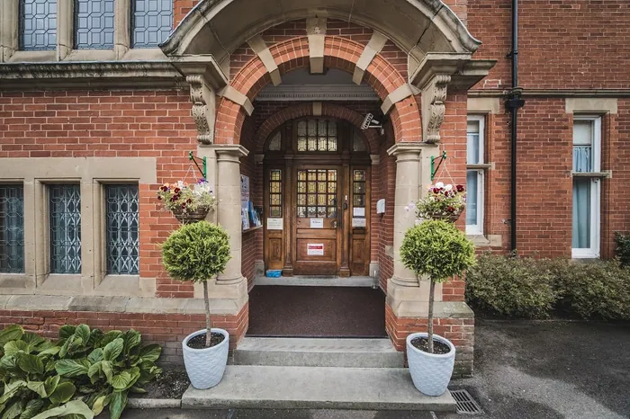 The brick arch and front door at Bridgedale House, with topiary either side