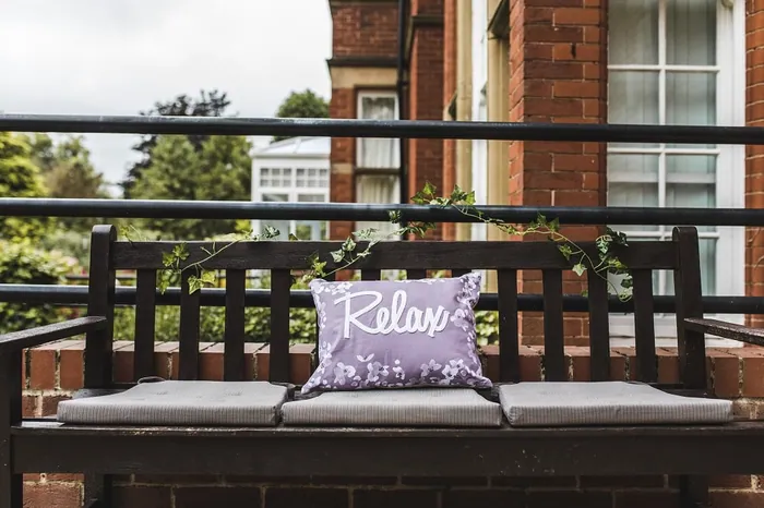 A garden bench with a 'Relax' cushion on the terrace