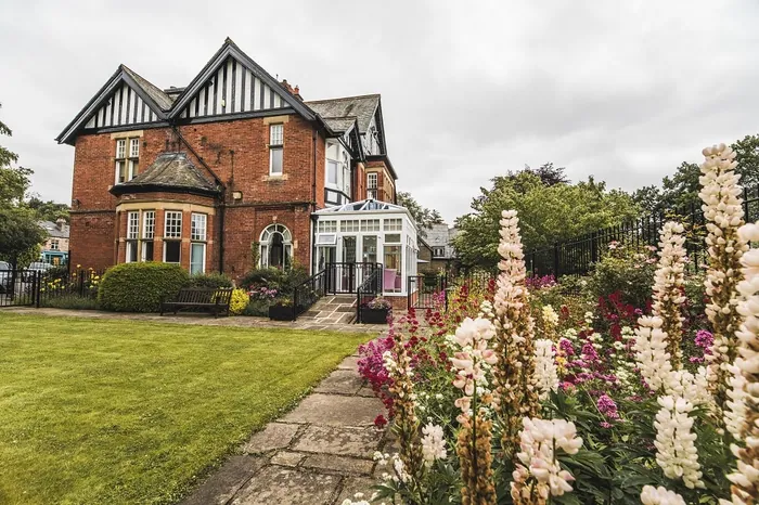 The front garden and path to Bridgedale House, with flowers in bloom