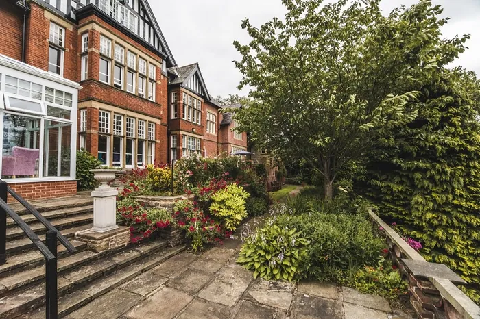 Bridgedale House's red-brick frontage, steps and garden shrubs