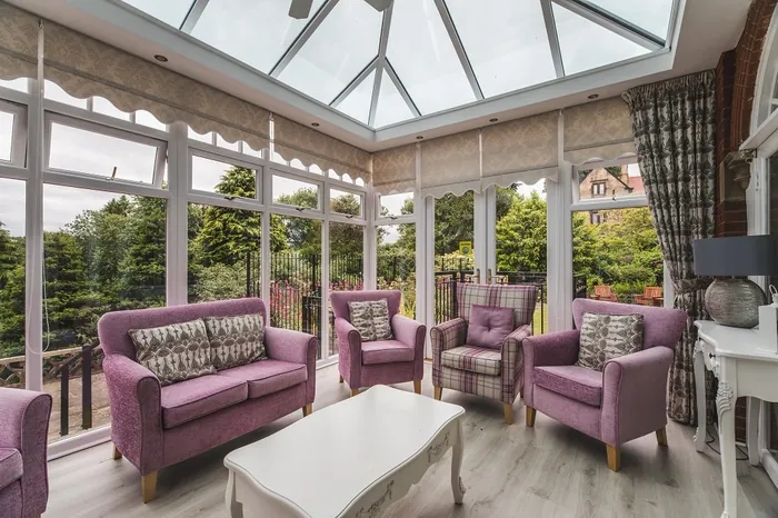 A wide view of the orangery's purple sofas and glass roof